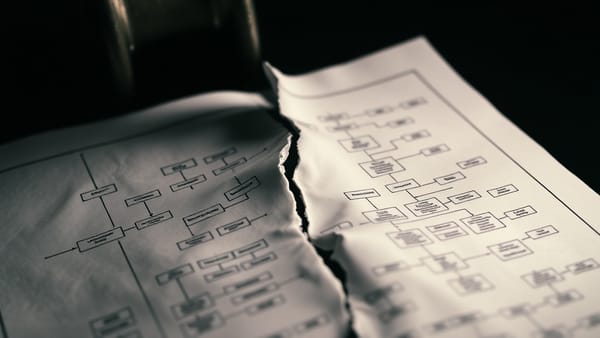 A no-code flowchart cracking under pressure, symbolizing architectural limits at scale